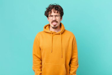 Genç yakışıklı adam iğreniyor, sinirleniyor ve dilini çıkarıyor.