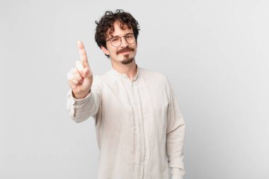 Genç yakışıklı adam gülümsüyor ve arkadaş canlısı görünüyor.