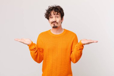 Genç yakışıklı adam şaşkın, şaşkın ve şüpheci hissediyor.