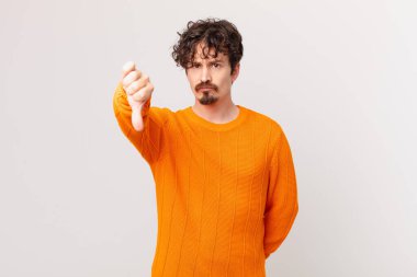 Genç ve yakışıklı adam kendini kötü hissediyor, baş parmağını kaldırıyor.