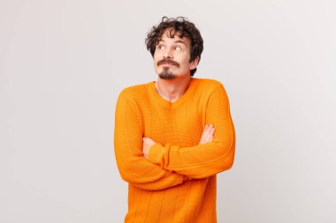 Genç yakışıklı adam omuz silkiyor, kafası karışık ve kararsız.