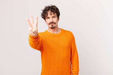 Genç yakışıklı adam gülümsüyor ve arkadaş canlısı görünüyor.