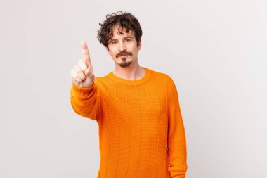 Genç yakışıklı adam gülümsüyor ve arkadaş canlısı görünüyor.