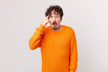 Genç yakışıklı adam şaşırmış görünüyor, yeni bir düşünce, fikir ya da konsept keşfediyor.