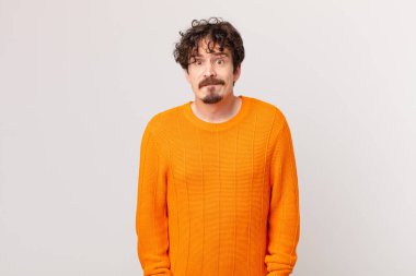 Şaşkın ve kafası karışmış genç yakışıklı bir adam.