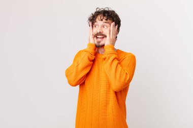 Genç yakışıklı adam mutlu, heyecanlı ve şaşırmış hissediyor.