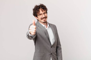 Genç işadamı gururlu, olumlu gülümsüyor.