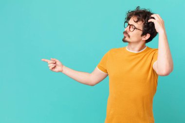 Kafası karışmış, kafası karışmış, kaşınan genç yakışıklı bir adam.