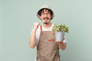 young farmer man feeling shocked,laughing and celebrating success