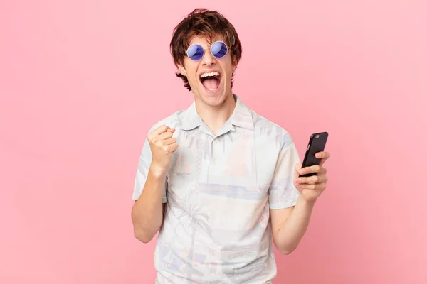 Νεαρός Άνδρας Ένα Κινητό Τηλέφωνο Αισθάνεται Σοκαρισμένος Γελώντας Και Γιορτάζοντας — Φωτογραφία Αρχείου