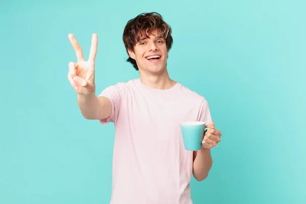 Jovem Com Uma Caneca Café Sorrindo Olhando Feliz Gesticulando Vitória — Fotografia de Stock