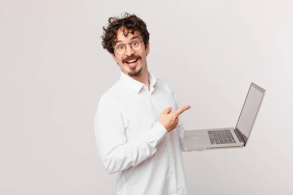 Νεαρός Άνδρας Ένα Φορητό Υπολογιστή Φαίνεται Ενθουσιασμένος Και Έκπληκτος Δείχνοντας — Φωτογραφία Αρχείου
