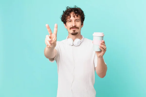 Jovem Com Café Sorrindo Olhando Amigável Mostrando Número Dois — Fotografia de Stock