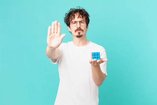 Young Man Solving Intelligence Problem Looking Serious Showing Open Palm — Foto de Stock