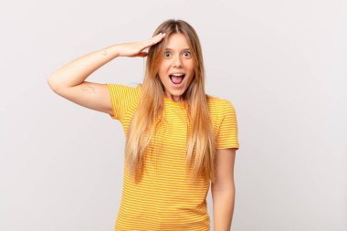Genç, güzel bir kadın mutlu, şaşkın ve şaşırmış görünüyor.