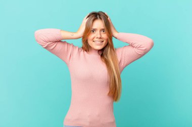 Genç ve güzel bir kadın stresli, endişeli ya da korkmuş hissediyor, elleri başının üstünde.