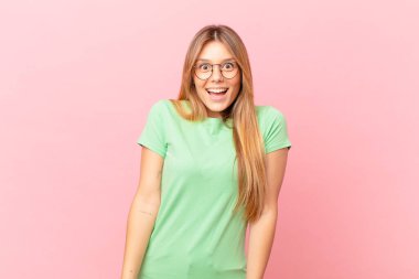 Genç ve güzel bir kadın mutlu ve hoş bir şekilde şaşırmış görünüyor.