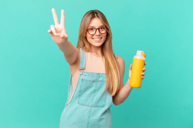 Gülümseyen ve mutlu görünen genç bir kadın, işaret eden zafer ya da huzur