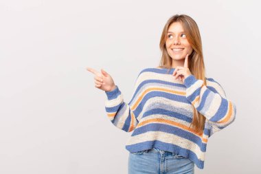 Genç ve güzel kız mutlu bir şekilde gülümsüyor ve hayal kuruyor.