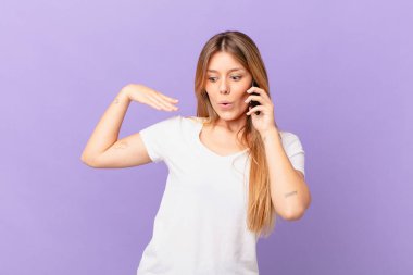 Cep telefonlu genç bir kadın stresli, endişeli, yorgun ve hayal kırıklığına uğramış.