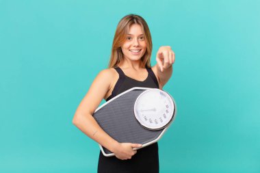 Genç, güzel bir fitness kadını kamerayı işaret ederek seni seçiyor.