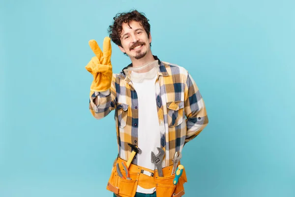 Young Handyman Housekeeper Smiling Looking Happy Gesturing Victory Peace — Fotografia de Stock