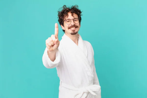 Joven Vestido Con Albornoz Sonriendo Orgullosa Confiadamente Haciendo Número Uno —  Fotos de Stock