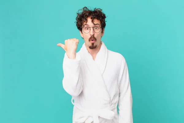 Young Man Wearing Bathrobe Looking Astonished Disbelief — Φωτογραφία Αρχείου