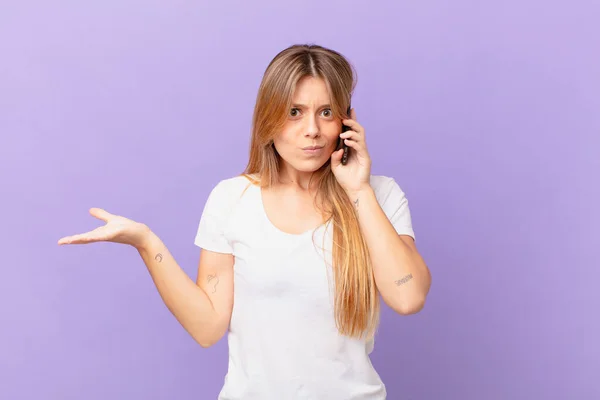 Jovem Com Telefone Celular Sentindo Intrigado Confuso Duvidoso — Fotografia de Stock