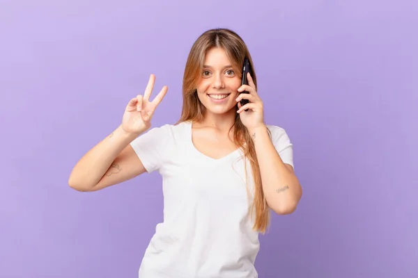 Mladá Žena Mobilním Telefonem Usmívá Vypadá Přátelsky Ukazuje Číslo Dvě — Stock fotografie