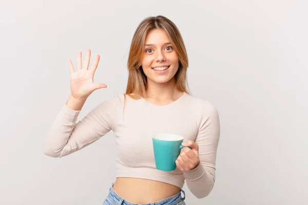 Jonge Vrouw Met Een Koffie Mok Glimlachend Zoek Vriendelijk Tonen — Stockfoto