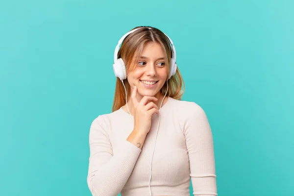 Ung Kvinna Med Hörlurar Ler Med Ett Lyckligt Självsäkert Uttryck — Stockfoto