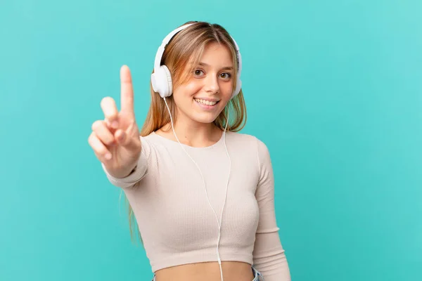 Mujer Joven Con Auriculares Sonriendo Orgullosa Confiadamente Haciendo Número Uno — Foto de Stock