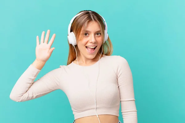 Mujer Joven Con Auriculares Sonriendo Alegremente Saludándote Con Mano Dándote — Foto de Stock