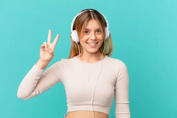 Mujer Joven Con Auriculares Sonriendo Buscando Amigable Mostrando Número Dos —  Fotos de Stock