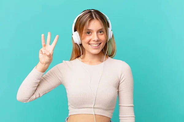 Mujer Joven Con Auriculares Sonriendo Buscando Amigable Mostrando Número Tres —  Fotos de Stock