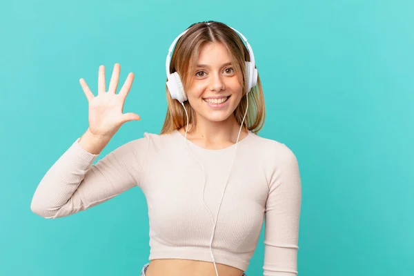 Mujer Joven Con Auriculares Sonriendo Buscando Amigable Mostrando Número Cinco —  Fotos de Stock