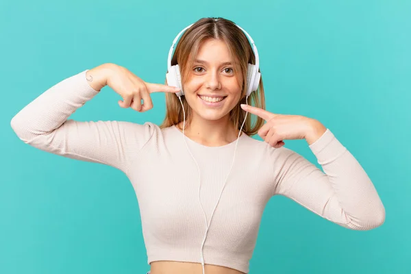 Jonge Vrouw Met Koptelefoon Glimlachend Vol Vertrouwen Wijzend Naar Eigen — Stockfoto