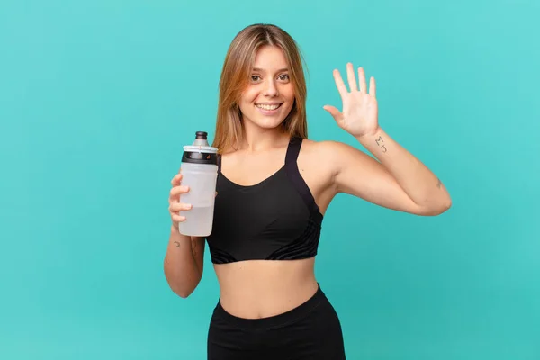 Jovem Bonita Mulher Fitness Sorrindo Olhando Amigável Mostrando Número Cinco — Fotografia de Stock