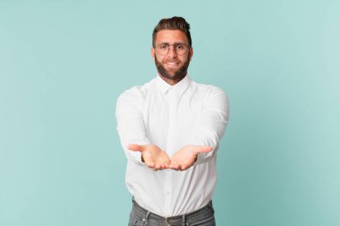 Genç yakışıklı adam mutlu bir şekilde gülümsüyor.