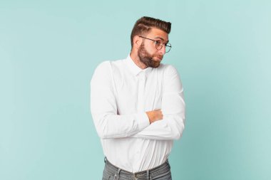 Genç yakışıklı adam omuz silkiyor, kafası karışık ve kararsız.