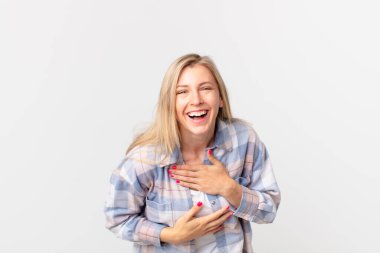 Genç sarışın bir kadın komik bir şakaya yüksek sesle gülüyor.