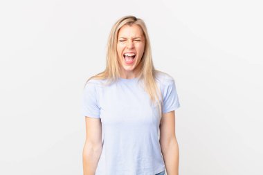 Genç sarışın kadın agresif bir şekilde bağırıyor, kızgın görünüyor.