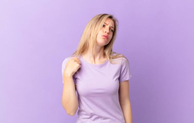 Genç sarışın kadın stresli, endişeli, yorgun ve hayal kırıklığına uğramış.