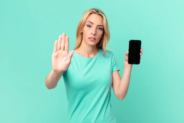 Młoda Blondynka Wygląda Poważnie Pokazując Otwartą Dłoń Stop Gest Trzymając — Zdjęcie stockowe