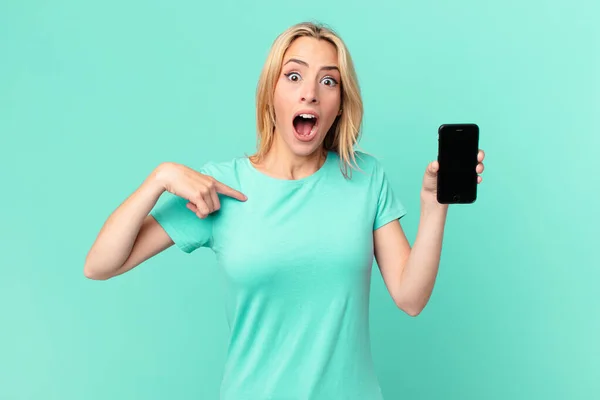 Młoda Blondynka Czuje Się Szczęśliwy Wskazując Siebie Podekscytowany Trzyma Smartfon — Zdjęcie stockowe