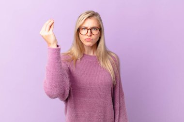 Genç sarışın kadın kapiş ya da para hareketi yapıyor, sana ödemeni söylüyor.