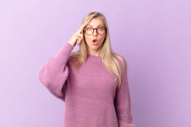 Genç sarışın kadın şaşırmış görünüyor, yeni bir düşünce, fikir ya da konsept fark ediyor.