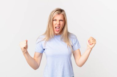 Genç sarışın kadın sinirli bir ifadeyle agresif bir şekilde bağırıyor.