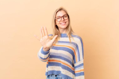 Genç sarışın kadın gülümsüyor ve arkadaş canlısı görünüyor.